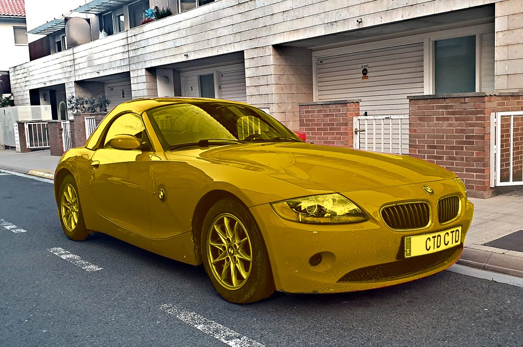 The same car recoloured yellow; street, walls and plate unchanged