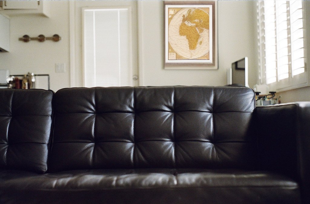 The same photo with the poster replaced by a framed vintage world map; everything else identical